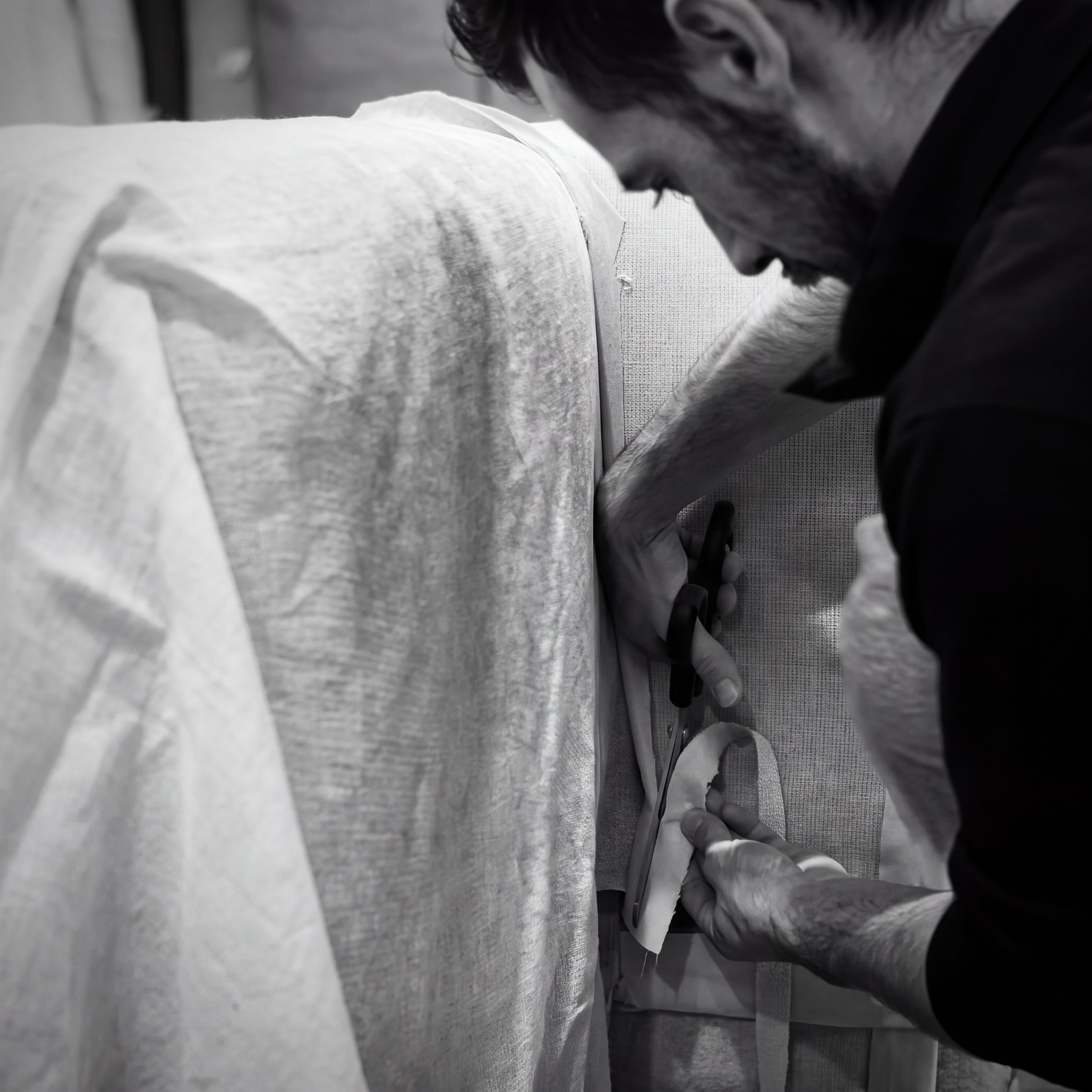 Tapissier découpant le tissu d'un canapé dans l'atelier